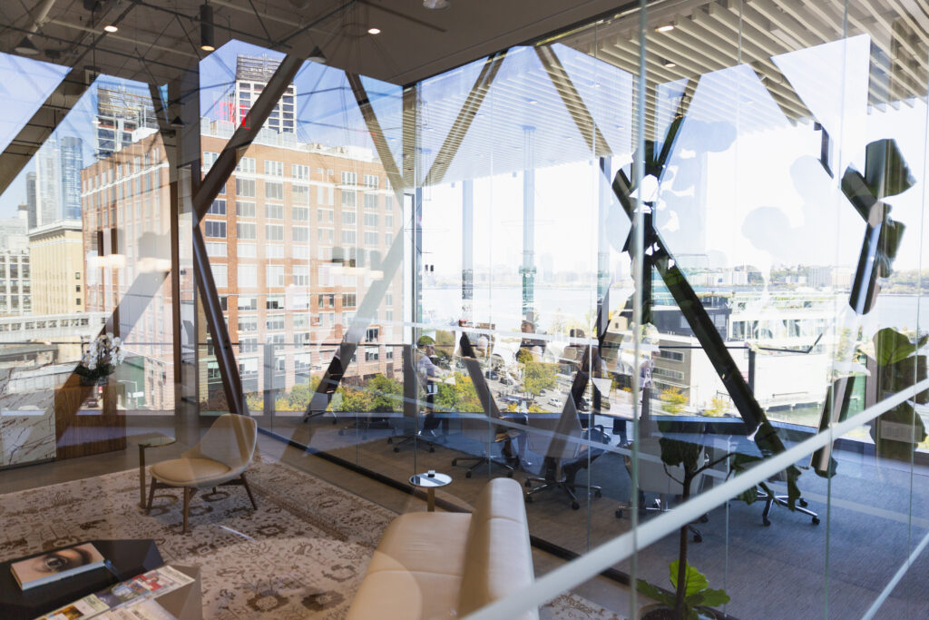 looking through reflective glass into a meeting room